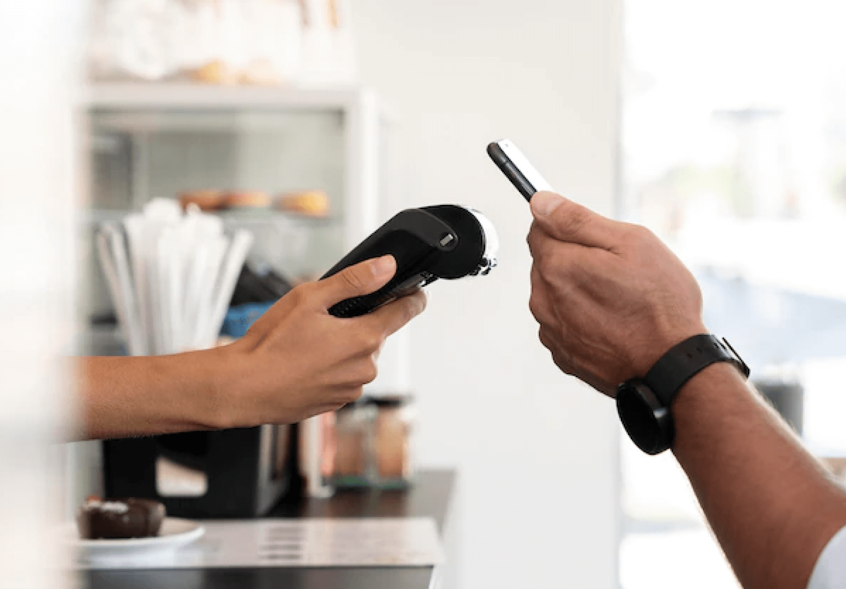 Maquinhinha de cartão e um celular fazendo o pagamento por aproximação